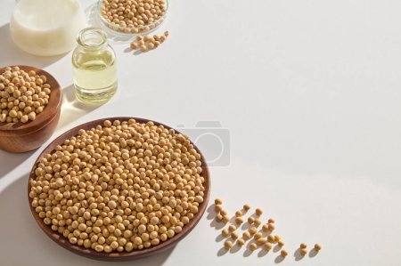 Foto de Aceite de soja, leche y semillas contenidas dentro de cristalería de laboratorio y recipientes de madera sobre fondo blanco. Espacio libre para la publicidad de productos - Imagen libre de derechos