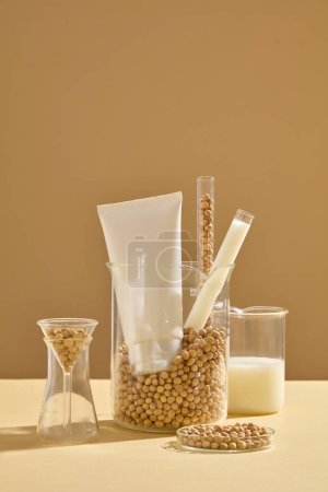 Photo for A large beaker containing many soybeans, test tubes and a empty label tube. Front view. Soybeans have vitamins A and E, particularly useful in reducing wrinkles - Royalty Free Image