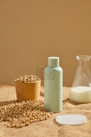 Photo for Cosmetic bottle displayed with a bowl of soybeans. A conical flask and petri dish of soybean milk featured. Natural cosmetic concept. Empty label for branding mockup - Royalty Free Image