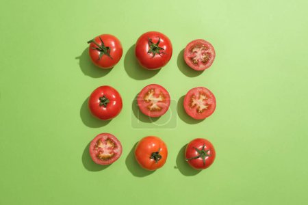 Foto de Vista superior de varios tomates y mitades de tomate están dispuestos en tres líneas. Frotar tomate en la cara todos los días asegurará que las células muertas de la piel - Imagen libre de derechos