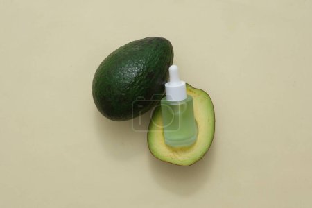 Photo for Skin care cosmetics with avocado extract formulation concept. Top view of dropper bottle with avocado slices on beige background. Space for design - Royalty Free Image
