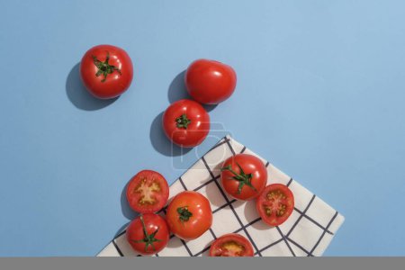 Foto de Varios tomates y mitades de tomate se muestran con una tela. El tomate (Solanum lycopersicum) en la cara ayuda a calmar la piel y prevenir las quemaduras solares - Imagen libre de derechos
