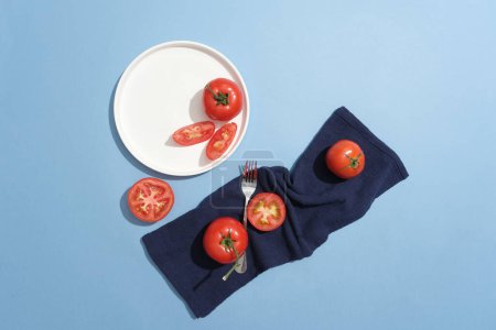 Foto de Vista superior de varias rebanadas de tomate expuestas en un plato de cerámica y una tela. El componente de vitamina C presente en los tomates los hace efectivos en la cicatrización de heridas - Imagen libre de derechos
