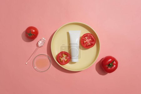 Photo for Ceramic dish containing a blank label tube and two slices of tomato. Mockup design. Several compounds in Tomato (Solanum lycopersicum) has an anti-inflammatory effect. - Royalty Free Image