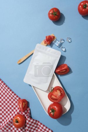 Foto de Rebanadas de tomate están decoradas con pocos cubitos de hielo y un paquete de máscara sin etiqueta. Concepto cosmético natural. Etiqueta vacía para maqueta de marca - Imagen libre de derechos