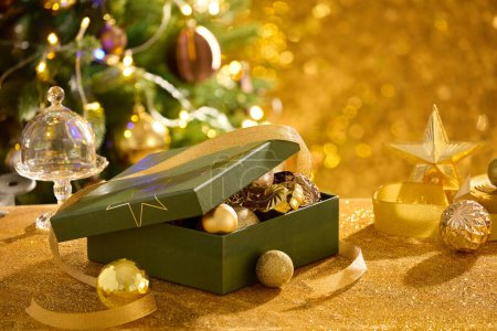 Téléchargez les photos : Vue rapprochée d'un coffret cadeau contenant beaucoup de boules de Noël décorées sur une table étincelante. Joyeux Noël et heureux nouveau concept de l'année - en image libre de droit