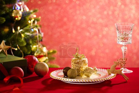 Foto de Plato de lujo cuenta con una caja de regalo y bolas brillantes en la superficie roja. Una de las decoraciones de Navidad más populares es el árbol de Navidad con muchos artículos de colores - Imagen libre de derechos
