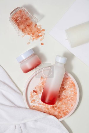 Photo for Top view of a jar and bottle without label arranged with lots of pink himalayan salt. Himalayan salt can work brilliantly as a scalp treatment. Branding mockup - Royalty Free Image