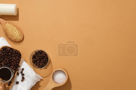 Foto de Bandeja de madera que contiene granos de café, polvo de café y sal de baño, decorada con vela y peine sobre fondo naranja. Espacio vacío para el producto de presentación y espacio de copia - Imagen libre de derechos