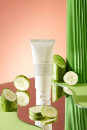 Photo for Geometric shaped mirror with some round slices of cucumber and unlabeled tube placed on. Natural cosmetic concept. Empty label for branding mockup - Royalty Free Image