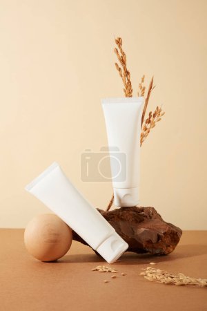 Photo for Two cosmetic tubes presented against a minimalist backdrop. Labels left blank for creative lettering and cosmetic branding. Emphasizing the concept of rice bran-derived cosmetics. - Royalty Free Image