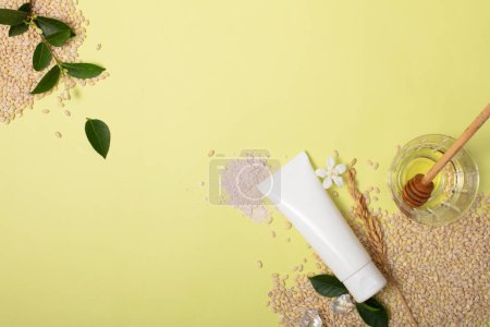 Téléchargez les photos : Tube nettoyant facial extrait de son de riz non étiqueté présenté sur fond de grains de riz entiers. Espace parfait pour promouvoir les cosmétiques végétaliens avec des ingrédients naturels. - en image libre de droit