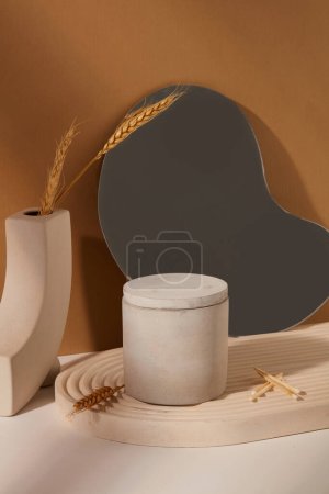 Photo for A jar of unlabeled scented candles is placed on a domed podium, an acrylic sheet and decorations on a white and brown background. Exquisite space. - Royalty Free Image