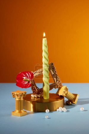 Photo for Front view of a burning candle displayed with vintage props on a blue-orange background. Copy space for birthdays or holidays. Uses of candles. - Royalty Free Image
