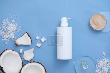 Photo for Some props, fresh coconuts and unlabeled cosmetic bottles are displayed against a pastel background. Copy space for cosmetics advertising. - Royalty Free Image