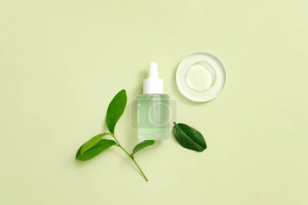 Photo for Organic serum with fresh green tea leaves, liquid drops displayed on a transparent platform, pastel background. Minimalist concept with beauty products. - Royalty Free Image