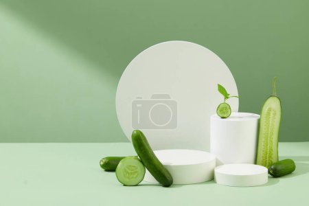 Téléchargez les photos : Disposez un podium blanc pour placer les produits, les concombres frais sont décorés sur un fond pastel. L'espace est adapté pour la publicité des cosmétiques naturels. - en image libre de droit