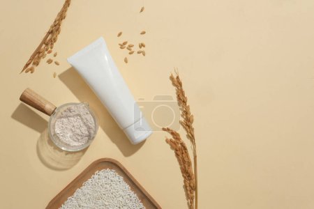 Photo for Rice, rice bran and an unlabeled white tube are placed on a beige background. Empty space for text design. Skin care with vegan cosmetics-safety for skin. - Royalty Free Image