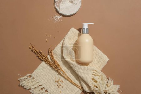 Photo for Rice flour is stored in a petri dish. An unlabeled bottle of shower gel is placed on a brown background with a beige tablecloth. Cosmetic advertising with ideal space. - Royalty Free Image