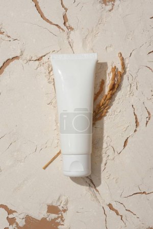 Photo for Close-up of a cosmetic tube on a background filled with rice bran powder. Rice bran powder contains many nutrients that are good for the skin. Concept of natural cosmetics. - Royalty Free Image
