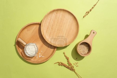 Photo for Wooden trays are placed on a green background for product display. Rice bran is stored in a small bowl. Rice bran has many magical uses in beautifying the skin that are both safe and effective. - Royalty Free Image