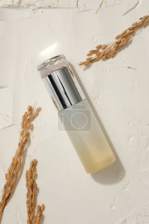 Photo for View from above of a beauty bottle placed on rice bran powder, decorated with wheat ears. Branding mockup. Rice water will help restore hair damage - Royalty Free Image