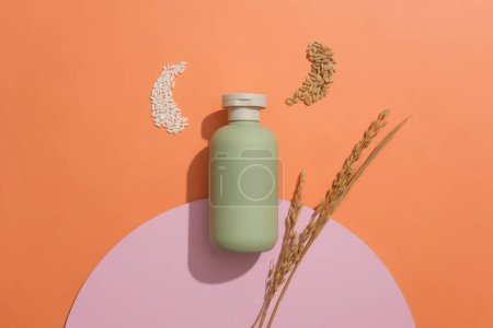 Photo for Empty label bottle in pastel green color displayed with handful of rice and wheat seeds. Flat lay. Mockup of skin care cosmetic bottle of beauty facial - Royalty Free Image