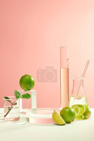 Téléchargez les photos : Les instruments de laboratoire et les citrons frais sont exposés sur un fond blanc-rose. podium en verre pour l'affichage des produits. Espace idéal pour la publicité cosmétique. - en image libre de droit