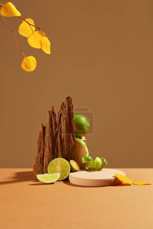 Téléchargez les photos : Des citrons frais sont exposés sur un fond brun avec un podium rose et du bois séché. Espace vide pour l'affichage du produit. Citron contient beaucoup de vitamine C qui est bon pour la peau. - en image libre de droit