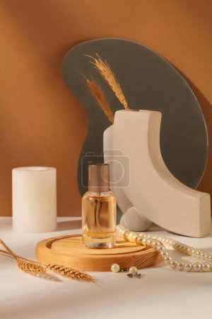 Photo for Background for branding and packaging presentation perfume product. A glass bottle without label on wooden podium displayed with pearl necklace, candle and wheat on brown background. Front view - Royalty Free Image