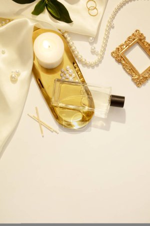 Photo for Flat lay, top view trendy lifestyle blog with decorative pearl jewelry on white background with candles and silk fabric. Mockup for unlabeled perfume bottle displayed for advertising. Copy space - Royalty Free Image