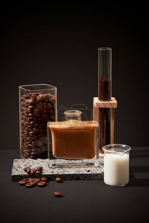 Photo for Ingredients for brewing milk coffee showcased against a black backdrop. Consistent consumption of caffeinated coffee is linked to lower risks of diabetes. Copy space. - Royalty Free Image