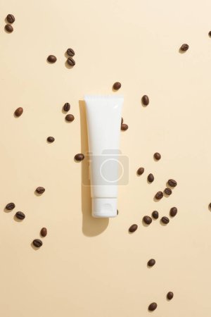 Photo for Coffee beans are scattered on a light pink background with a cosmetic tube without a label. Massaging with coffee powder increases skin elasticity and firmness. - Royalty Free Image