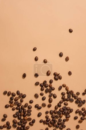 Téléchargez les photos : Des grains de café éparpillés sur un fond rose. Espace idéal pour afficher des produits contenant de l'extrait de café. Soyez créatif avec des grains de café pour la publicité. - en image libre de droit