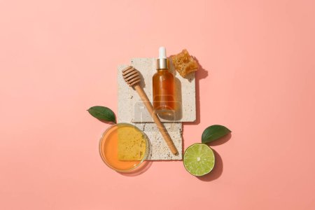 Photo for Glass serum bottle displayed on stone podium with a honey dripping, beeswax and a petri dish of honey. Natural beauty spa product concept - Royalty Free Image