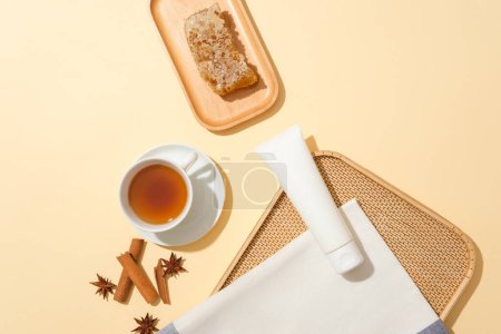 Foto de Tubo sin marca se muestra con una taza de té y plato de madera de cera de abeja. La miel cruda contiene muchos antioxidantes importantes. Anís estrellado y canela destacados - Imagen libre de derechos