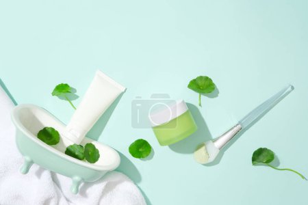 Photo for An unlabeled skincare set is displayed with fresh pennywort and props against a light blue background. Gotu kola helps reduce inflammation and redness caused by problems such as acne. - Royalty Free Image