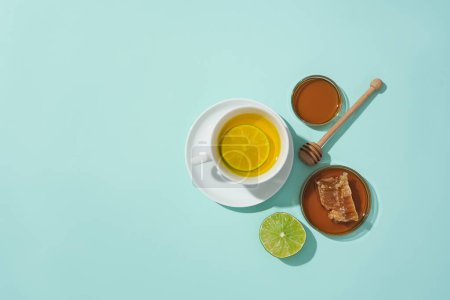 Téléchargez les photos : Gros plan d'une tasse de thé citron-miel sur fond bleu. Dans les aliments, le miel est utilisé comme édulcorant naturel. Espace gratuit pour la publicité alimentaire naturelle. Espace de copie. - en image libre de droit