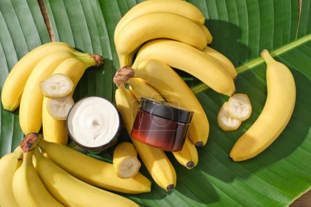 Two unlabeled jars contained cream texture decorated with several banana slices. Beauty product extracted from Banana (Musaceae) help to fade age spots and prevent fine lines and wrinkles