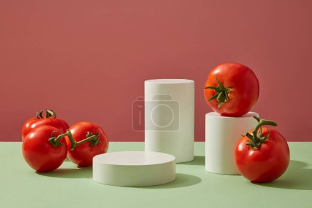 Photo for Advertising scene for cosmetic of tomato extract. Cylinder white podiums arranged with fresh tomatoes on color background. Pedestal for cosmetic product and packaging mockups display presentation - Royalty Free Image