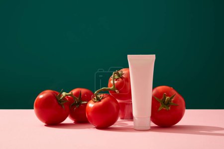 A white plastic bottle decorated with ripe tomatoes on color background. Mockup for cosmetic. Tomatoes contain compounds that help shrink pores, treat acne and brighten skin tone.
