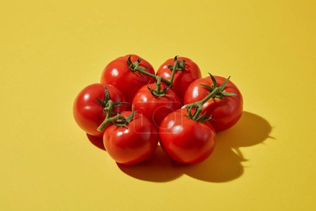 Sur fond jaune, des tomates fraîches mûres décorées. Les tomates contiennent beaucoup de vitamines A, C et B6 qui sont bonnes pour la peau et les cheveux