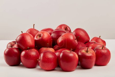 Foto de Las manzanas rojas maduras se muestran prominentemente sobre un fondo blanco. Escena para publicidad cosmética o producto con ingredientes de manzana roja, de origen natural y muchos usos para la salud y la belleza - Imagen libre de derechos