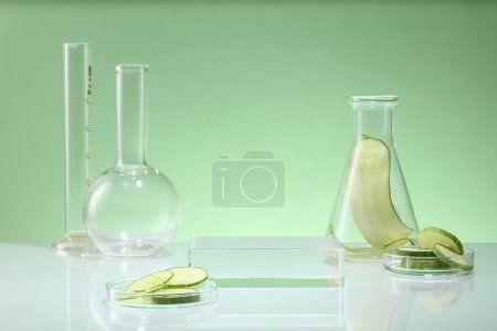 Photo for Front view of lab glassware decorated on pastel background with cucumber slices. Empty transparent podium for display cosmetic of cucumber extract. Concept of scientific research in the laboratory - Royalty Free Image
