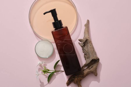 Photo for Flat lay cosmetic mockup on pink background with petri dishes containing liquid and foam, dry twig and flower branch. An amber bottle container shampoo. Advertising photo - Royalty Free Image