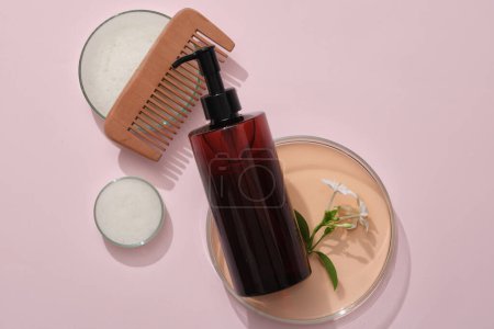 Photo for Minimal empty display product presentation scene with amber bottle unlabeled on pink background decorated with petri dishes, comb and flower branch. Space for design - Royalty Free Image