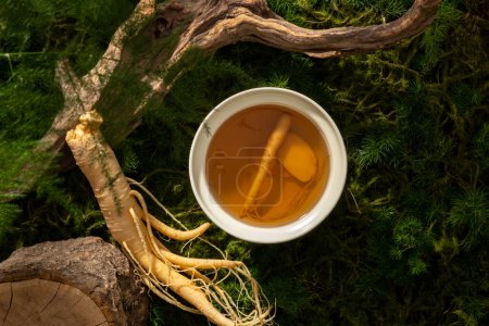 A bowl of tonic water from ginseng root on forest background, moss, leaves and dried twigs. Scene for advertising product of ginseng extract with natural concept.