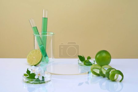Front view of empty podium, lab glassware filled green liquid, flower, leaves and fresh limes on color background. Concept of research and development of cosmetics with limes extracts