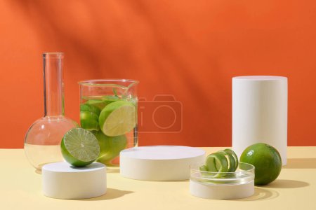 Laboratory glassware containing fresh limes and white empty podiums decorated on orange background with shadow leaves. Advertising scene for cosmetic products with lime extract.