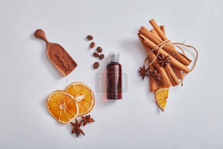 Photo for Flat lay cosmetic mockup with brown bottle without label, cinnamon sticks, anise, dried orange slices and coffee on white background. Health herbs, headache relief and reduce stress - Royalty Free Image